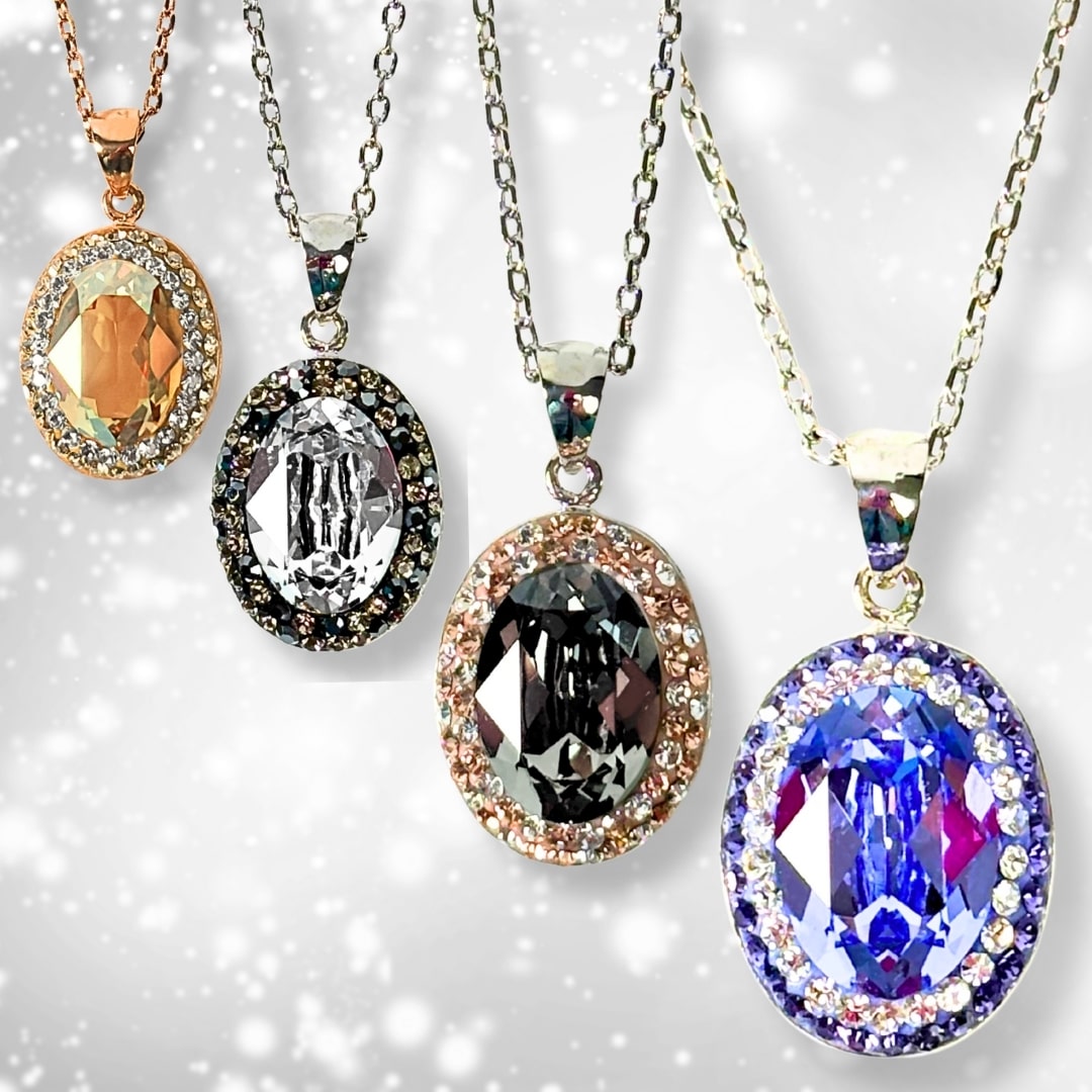 Classic oval pendant with European crystals in four colors, hanging against a white wall background, showcasing its timeless sparkle